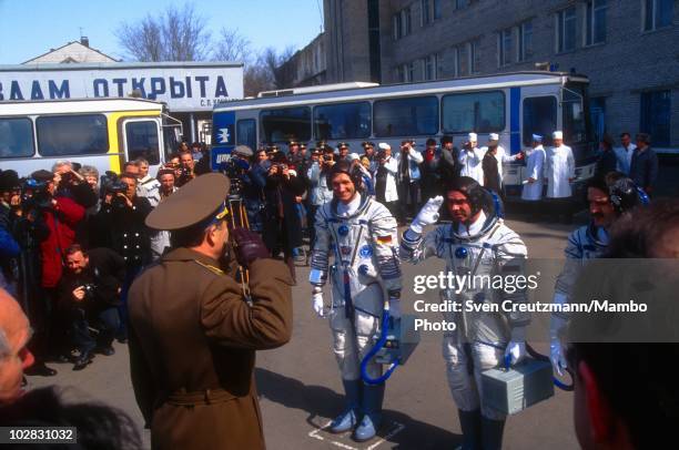 German astronaut Klaus Dietrich Flade and Russian cosmonauts salute to Russian military officials prior to boarding the spacecraft that will take...