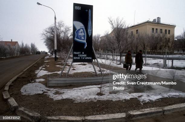 Baikonur inhabitants walk past propaganda signs that show images of Russia�s space history, on March 16 in Baikonur, Kazakhstan. Baikonur, located in...