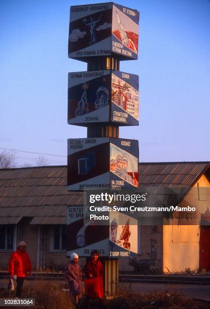 Baikonur inhabitants walk past propaganda signs that show images of Russia�s space history, on March 16 in Baikonur, Kazakhstan. Baikonur, located in...