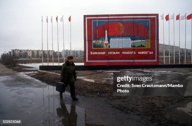 Russian military walks past propaganda signs that show images of Russia�s space history, on March 16 in Baikonur, Kazakhstan. Baikonur, located in...