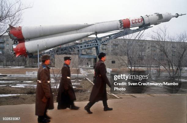 Russian military walk past a rocket spacecraft, exhibited in the streets, on March 16 in Baikonur, Kazakhstan. Baikonur, located in the steppes of...