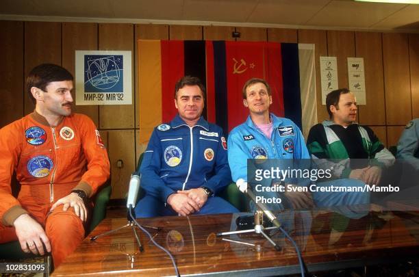 German astronaut Klaus Dietrich Flade and Russian cosmonauts Aleksandr Kaleri and Aleksandr Viktorenko sit behind a wall of glass as they give a...