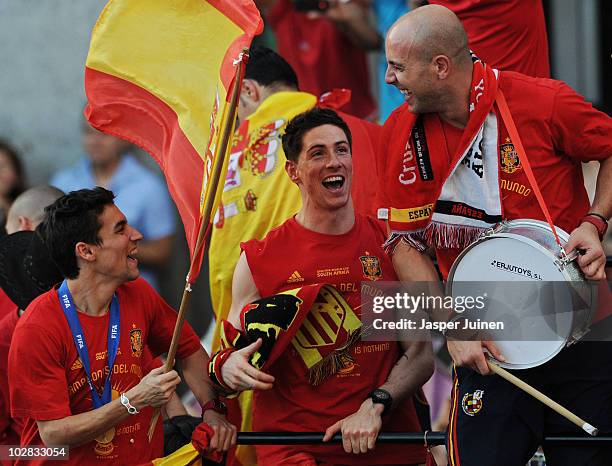 Fernando Torres of Spain celebrates with his teammates goalkeeper Pepe Reina and Jesus Navas during the Spanish team's victory parade following their...