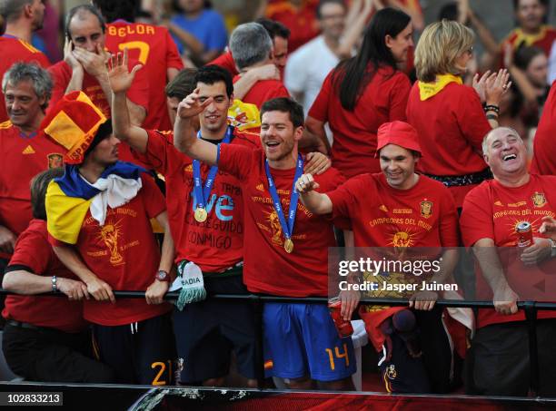 Xabi Alonso of Spain celebrates with his teammates Andres Iniesta and Raul Albiol during the Spanish team's victory parade following their victory in...