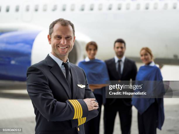 happy pilot with his crew next to an airplane - crew stock pictures, royalty-free photos & images