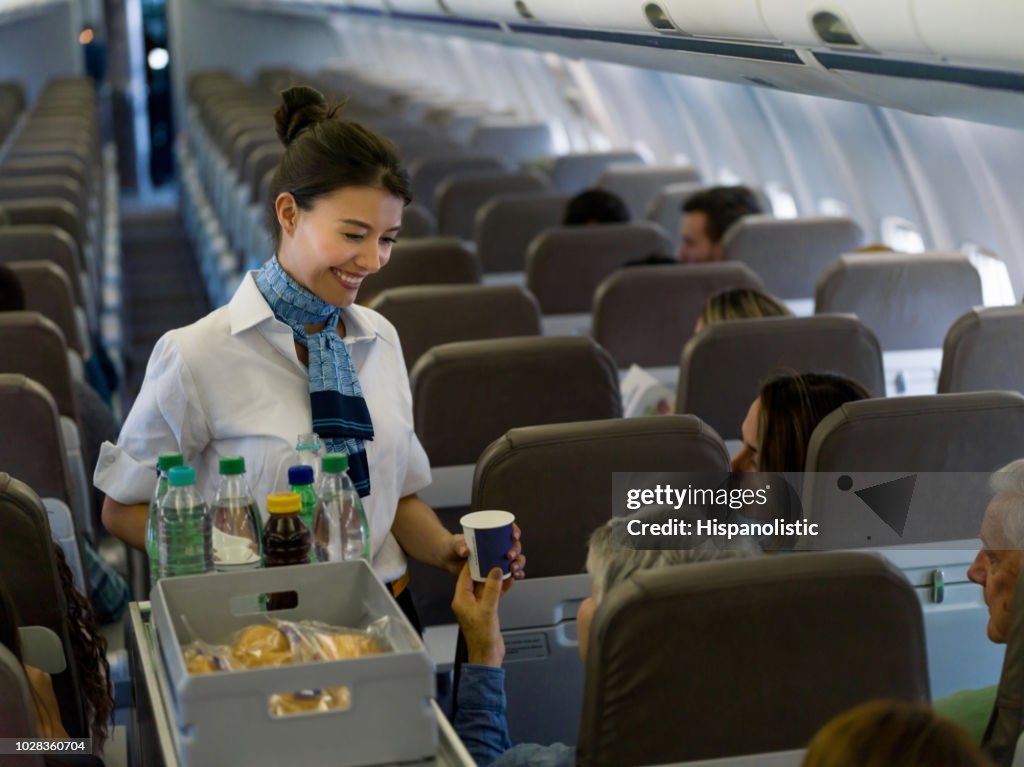 飛行機でフレンドリーな乗務員を提供のドリンクします。