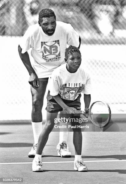 With her coach and father, Richard WIlliams, behind her, American tennis player Serena Williams waits for a serve during a training session at the...