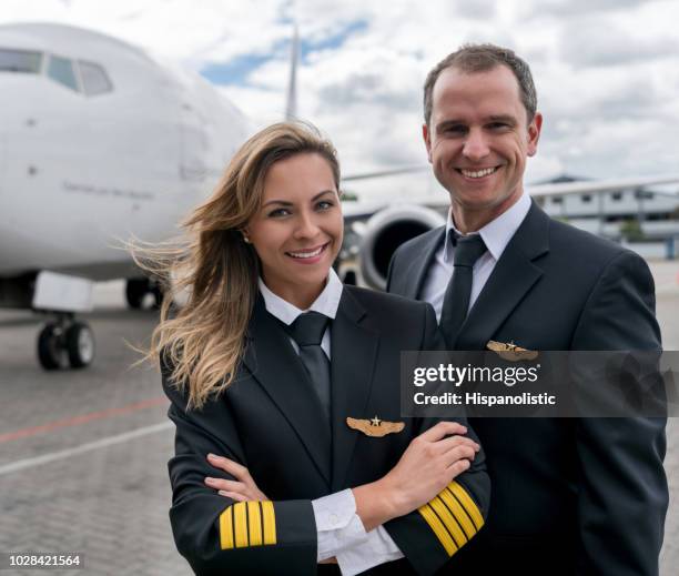 team of pilots next to an airplane - airline pilot stock pictures, royalty-free photos & images