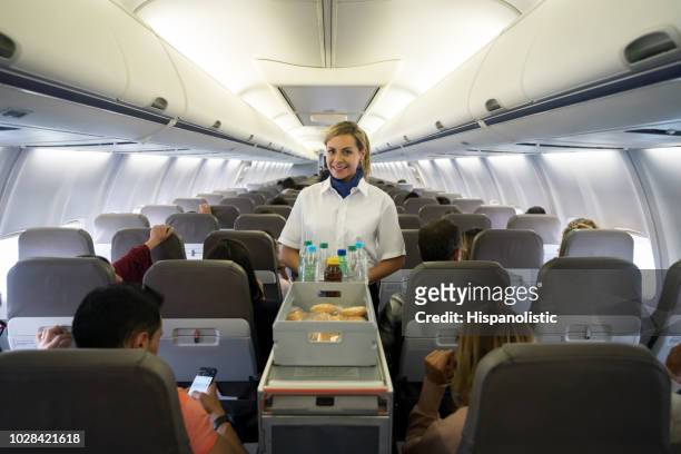 freundliche flugbegleiter, die speisen und getränke im flugzeug - airline food stock-fotos und bilder