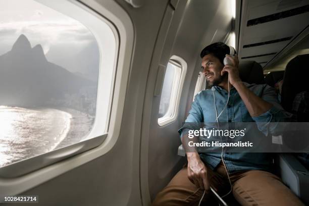 man traveling by plane and listening to music - airplane window stock pictures, royalty-free photos & images