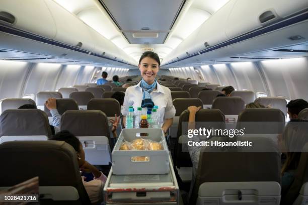 flight attendant serving drinks in an airplane - air stewardess stock pictures, royalty-free photos & images