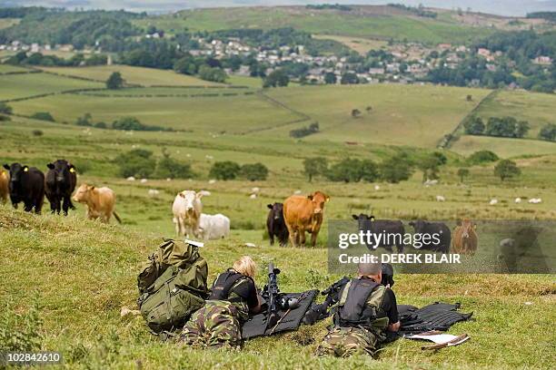 Police marksmen lie in the grass during their search for Raoul Moat, on the hills surrounding Rothbury, in northeast England on July 7, 2010. British...