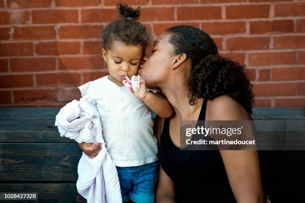 gemengd ras zusters portret buitenshuis op een bakstenen muur. - pacifier stockfoto's en -beelden