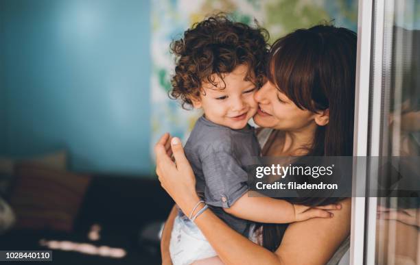 portrait of mother and son unconditional love - boy hugs mother stock pictures, royalty-free photos & images