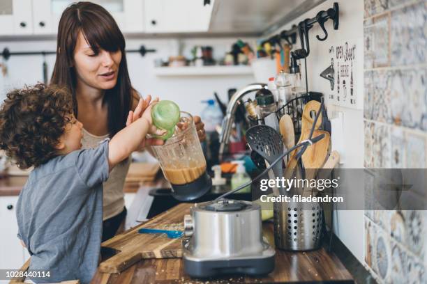 mutter und ihr kleiner sohn gesunde smoothie zubereitung - mixer stock-fotos und bilder