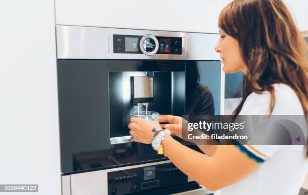 vrouw met koffiemachine - koffiemachine stockfoto's en -beelden