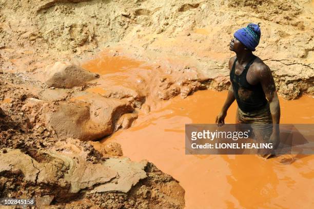 Man stands in a pool of water in a gold mine on February 23, 2009 in Chudja, near Bunia, north eastern Congo. The conflict in Congo has often been...