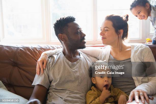 Affectionate multi-ethnic young family on living room sofa