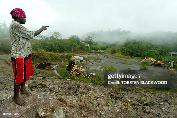 Rexley Rere points out the remains of the once prosperous Gold Ridge mine machine workshop in central Guadalcanal, 19 July 2003, which was forced to...