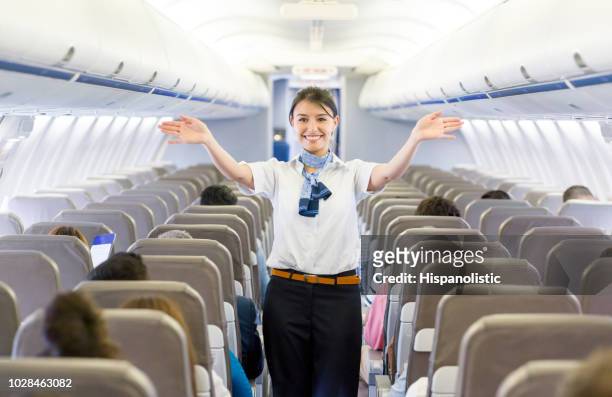 flight attendant showing the emergency exit in an airplane - crew stock pictures, royalty-free photos & images