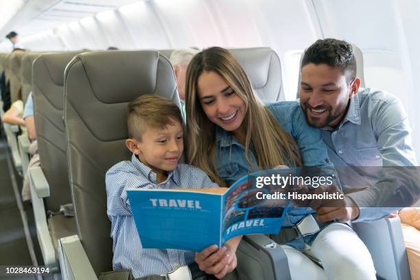 familie reisen mit dem flugzeug und einen reiseführer lesen - flying reading stock-fotos und bilder