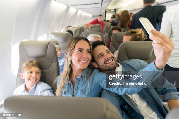 feliz familia viajando en avión y tomar un selfie - aircraft wifi fotografías e imágenes de stock