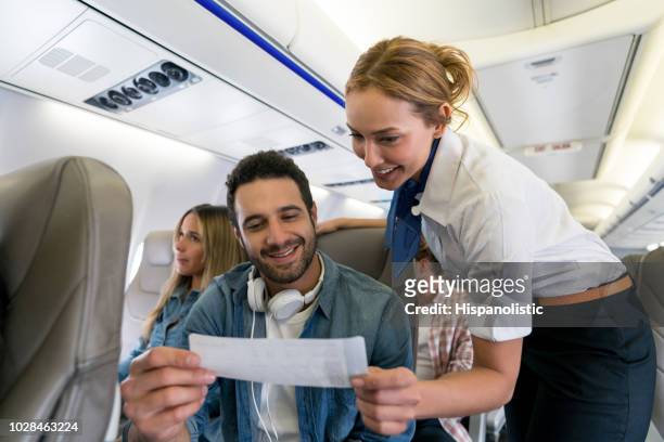 flight attendant überprüfung eines mannes sitz und ihren boarding pass - aisle seat airline stock-fotos und bilder