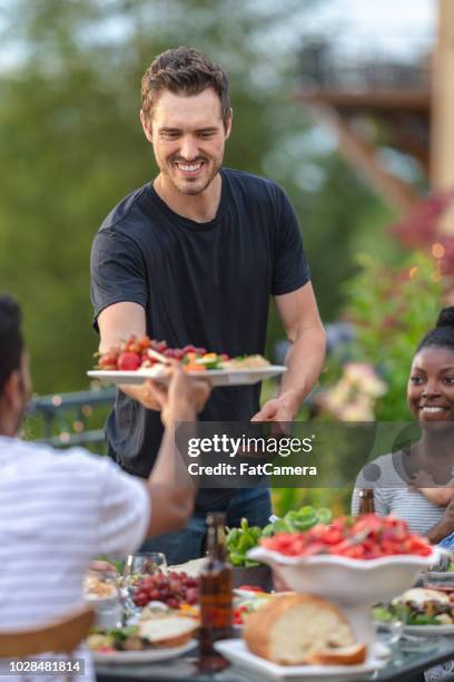 eine gruppe von jungen erwachsenen freunden essen im freien auf der terrasse - filipino family dinner stock-fotos und bilder