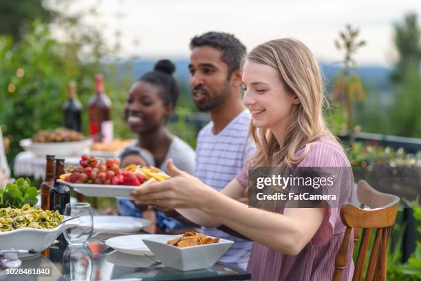 un grupo de jóvenes amigos adultos, comedor al aire libre en un patio - filipino family dinner fotografías e imágenes de stock