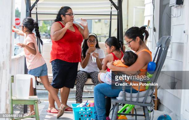 die große, glückliche latino mexikanisch-amerikanischen familie ruhen auf der veranda seines hauses - hot mexican girls stock-fotos und bilder