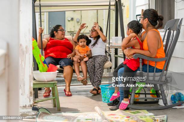 the big happy latino mexican-american family resting at the porch of his house - hot mexican girls stock pictures, royalty-free photos & images