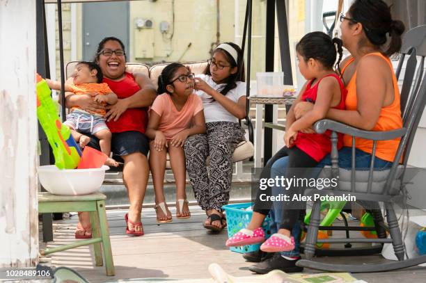 de grote en gelukkige latino-mexicaans-amerikaanse familie rust op de veranda van zijn huis - hot big women stockfoto's en -beelden