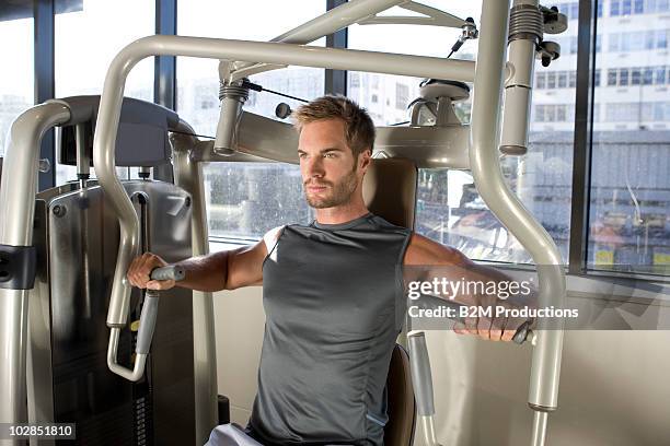 man working out in gym - フィットネスマシン ストックフォトと画像