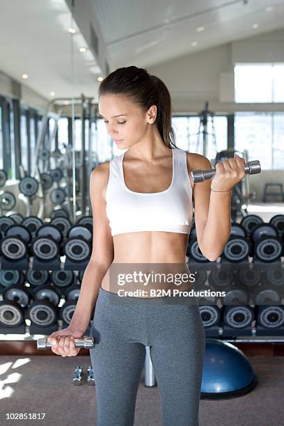 young woman exercising with dumbbell - hand weight stock pictures, royalty-free photos & images