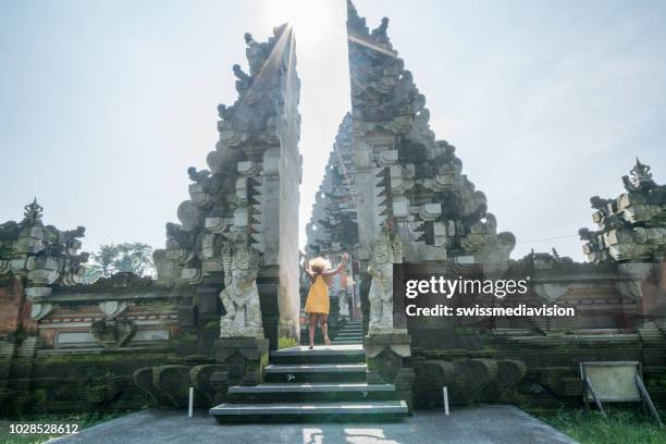 woman spinning around dancing like happy girl in front of temple's entrance at gate in ubud, bali- indonesia- people travel destinations fun lifestyles concept - bali dancing stock pictures, royalty-free photos & images