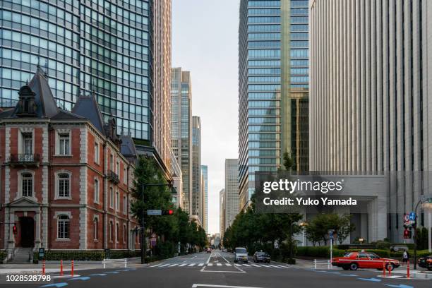 road amidst high-rise building during  morning - marunouchi stock pictures, royalty-free photos & images