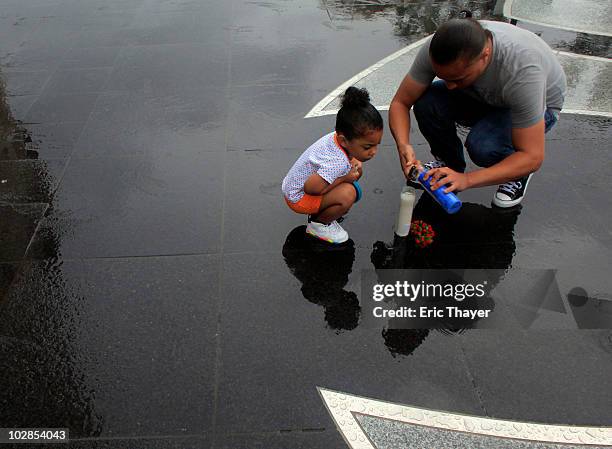 Edwin Roman of the Bronx, and his daughter Alanna place candles and flowers at Gate 4 after the death of George Steinbrenner July 13, 2010 at Yankee...
