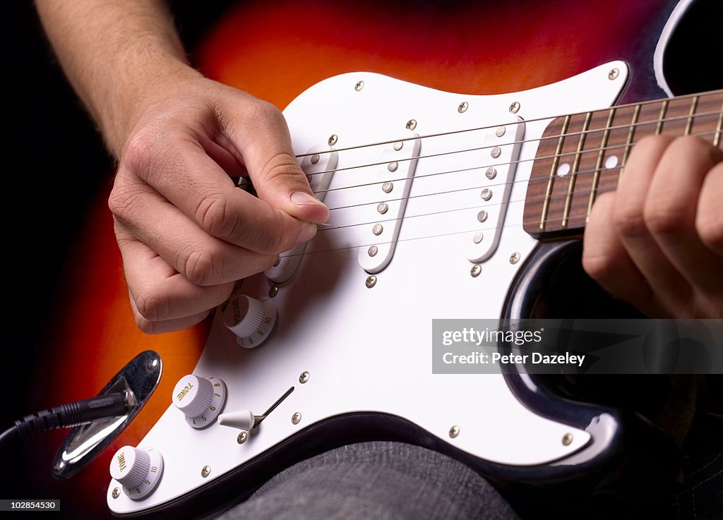 Playing solid electric guitar close up