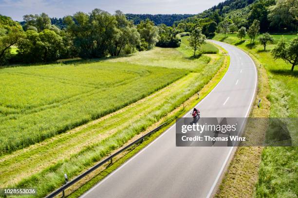 motorcycle on country road - landstraße stock-fotos und bilder