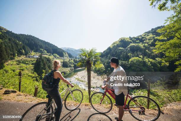 young couple stop to enjoy the view cycling in the mountains - iya valley stock pictures, royalty-free photos & images