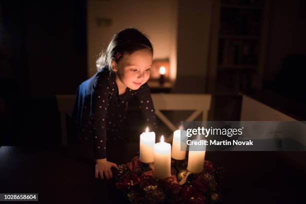 girl watching lights of advent wreath at home - kids advent stock pictures, royalty-free photos & images