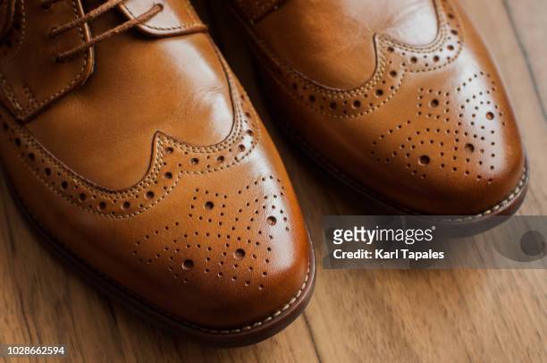 a pair of brown derby shoes with full brogue - zapato de cuero fotografías e imágenes de stock
