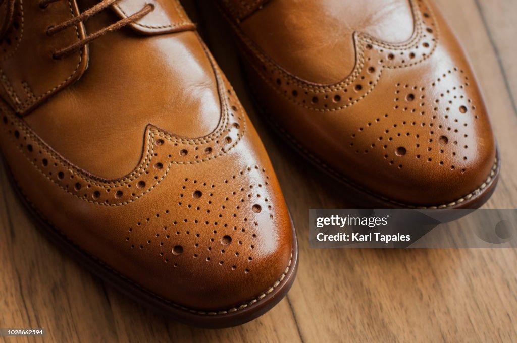 A pair of brown derby shoes with full brogue