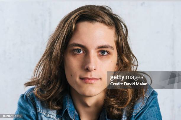 portrait of a long haired young man in a denim shirt. - androgynous - fotografias e filmes do acervo