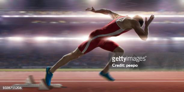 sprinter high speed burst from blocks at stadium athletics event - sprinting stock pictures, royalty-free photos & images