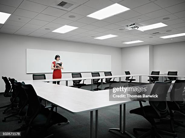 businesswoman standing alone in conference room - making choice stock pictures, royalty-free photos & images