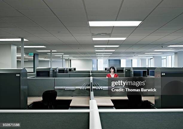 businesswoman standing alone in empty office - en blanco fotografías e imágenes de stock