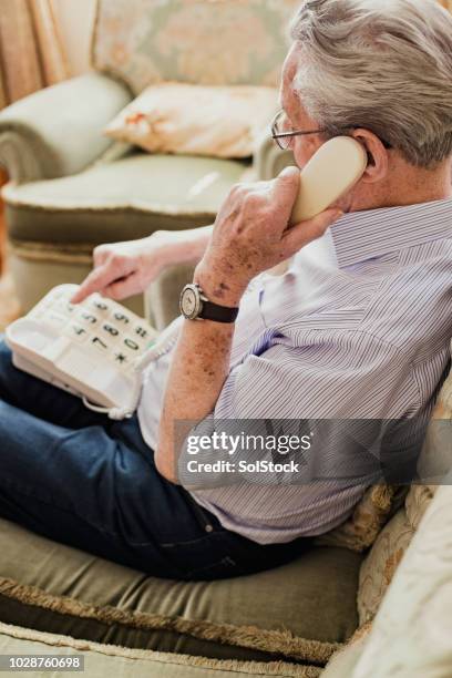 senior man dialling a number in the phone - landline telephone stock pictures, royalty-free photos & images