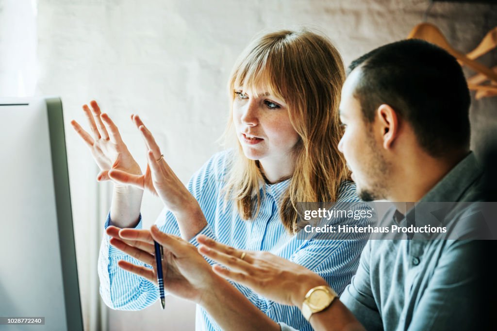 Colleagues Problem Solving At Computer Together