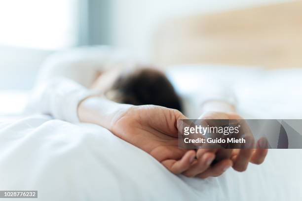 woman relaxing on a bed. - hands resting stock pictures, royalty-free photos & images